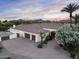 Home exterior with mature trees, a circular driveway, and attached garages, offering ample parking and curb appeal at 7129 E Caron Dr, Paradise Valley, AZ 85253