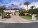 Elegant house with a circular driveway, mature trees, and lush landscaping under a colorful sky at 7129 E Caron Dr, Paradise Valley, AZ 85253