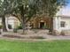 Elegant home featuring a stone fountain, lush landscaping, and a grand entrance with stately columns at 7129 E Caron Dr, Paradise Valley, AZ 85253