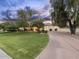 Attractive home exterior with a long driveway and well-manicured lawn, showcasing lush trees and landscaping at 7129 E Caron Dr, Paradise Valley, AZ 85253