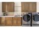 Spacious laundry room with wood cabinets, a countertop, stainless steel sink, and front load washer and dryer at 7129 E Caron Dr, Paradise Valley, AZ 85253