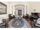 Grand living room featuring elegant columns, hardwood floors, a piano, and a sophisticated black and white rug at 7129 E Caron Dr, Paradise Valley, AZ 85253