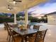 Elegant outdoor dining area under a covered patio, featuring a mountain view and lush landscaping at 7129 E Caron Dr, Paradise Valley, AZ 85253