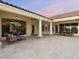A sprawling outdoor patio area featuring a seating area, outdoor dining area, tile flooring, and white columns at 7129 E Caron Dr, Paradise Valley, AZ 85253