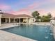 Stunning pool featuring a cascading waterfall, lounge chairs in the water, and a beautiful home in the background at 7129 E Caron Dr, Paradise Valley, AZ 85253
