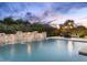Beautiful pool area with a waterfall feature, lush greenery, and a cozy fire pit lounge area at 7129 E Caron Dr, Paradise Valley, AZ 85253