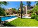 Lush backyard with pool, waterfall feature, grass, and lounge area for outdoor enjoyment at 7475 E Gainey Ranch Rd # 4, Scottsdale, AZ 85258
