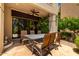 Inviting covered patio with ceiling fan, stone flooring, and seating for outdoor dining at 7475 E Gainey Ranch Rd # 4, Scottsdale, AZ 85258
