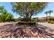 Attractive community entrance with brickwork, lush landscaping, and secure gates at 7475 E Gainey Ranch Rd # 4, Scottsdale, AZ 85258