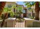 Beautiful home exterior with lush palm trees and arched entry, enhancing its curb appeal and Mediterranean charm at 7475 E Gainey Ranch Rd # 4, Scottsdale, AZ 85258