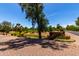 Scenic view of the golf course entry with lush landscaping and mature trees at 7475 E Gainey Ranch Rd # 4, Scottsdale, AZ 85258