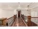 Upstairs hallway featuring hardwood floors, decorative iron railing, and custom lighting fixture at 7475 E Gainey Ranch Rd # 4, Scottsdale, AZ 85258