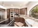 The eat-in kitchen boasts an island, stainless steel appliances, wood cabinets, light stone countertops, and mosaic tile backsplash at 7475 E Gainey Ranch Rd # 4, Scottsdale, AZ 85258