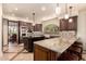 Open eat-in kitchen boasts a large island, stainless steel appliances, mosaic tile backsplash, and a view of the dining room at 7475 E Gainey Ranch Rd # 4, Scottsdale, AZ 85258