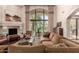 Bright living room featuring a cozy seating area, fireplace, and a large arched window with outdoor views at 7475 E Gainey Ranch Rd # 4, Scottsdale, AZ 85258