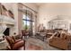 Bright living room featuring a cozy seating area, fireplace, and a large arched window with outdoor views at 7475 E Gainey Ranch Rd # 4, Scottsdale, AZ 85258