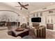 Comfortable living room featuring a ceiling fan, tv, and built-in shelving units, with an archway to the dining room at 7475 E Gainey Ranch Rd # 4, Scottsdale, AZ 85258