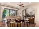 Spacious living room with large windows overlooking the yard, plus comfortable seating, ceiling fan, and an open archway at 7475 E Gainey Ranch Rd # 4, Scottsdale, AZ 85258