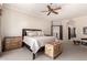 Comfortable main bedroom with ceiling fan, upholstered bedframe, trunk, and neutral carpeting at 7475 E Gainey Ranch Rd # 4, Scottsdale, AZ 85258