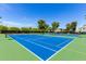 Exterior shot of multiple outdoor pickleball courts with blue playing surfaces and lush green surroundings at 7475 E Gainey Ranch Rd # 4, Scottsdale, AZ 85258