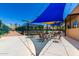 Outdoor community area with tennis courts, shaded tables and seating under bright blue and yellow sunshades at 7475 E Gainey Ranch Rd # 4, Scottsdale, AZ 85258