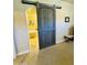 Bedroom view of a dark sliding barn door with bathroom view to the tub and tiled flooring at 7601 E Indian Bend Rd # 1049, Scottsdale, AZ 85250