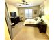 Cozy bedroom with neutral walls, ceiling fan, a dark wood dresser and a dark sliding barn door at 7601 E Indian Bend Rd # 1049, Scottsdale, AZ 85250