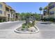 Gated community entrance with lush landscaping and mature trees at 7601 E Indian Bend Rd # 1049, Scottsdale, AZ 85250