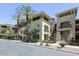 Multi-level building with neutral-colored exterior, balconies, palm trees, and well-maintained landscaping at 7601 E Indian Bend Rd # 1049, Scottsdale, AZ 85250