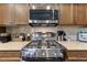 Close-up of the kitchen featuring a stainless steel range, granite countertops, and tiled backsplash at 7601 E Indian Bend Rd # 1049, Scottsdale, AZ 85250