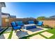 Backyard with a fire pit, synthetic grass, patio seating, and a privacy fence at 8138 E Jacaranda St, Mesa, AZ 85207