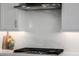 Modern kitchen featuring a cooktop with a stainless steel range hood and white countertops at 8138 E Jacaranda St, Mesa, AZ 85207