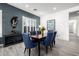Elegant dining room with blue chairs, a dark accent wall, and shutters on the window at 8138 E Jacaranda St, Mesa, AZ 85207