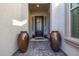 Inviting home entrance featuring potted plants, decorative vases, and a welcoming doormat at 8138 E Jacaranda St, Mesa, AZ 85207