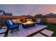 Cozy backyard fire pit with comfortable seating, set on a paved area with artificial turf accents at 8138 E Jacaranda St, Mesa, AZ 85207