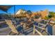 Outdoor community firepit with natural stone surround and adirondack seating at 8138 E Jacaranda St, Mesa, AZ 85207