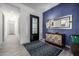 Stylish foyer featuring a blue accent wall, decorative mirror, and elegant rug at 8138 E Jacaranda St, Mesa, AZ 85207