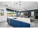 Bright kitchen with a large island, blue cabinets, and sliding doors leading to the outdoor pool area at 8138 E Jacaranda St, Mesa, AZ 85207