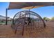 Climbing structure at a community playground has shade structure and wood chip base at 8138 E Jacaranda St, Mesa, AZ 85207
