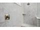 Detailed view of a modern shower with marble-patterned walls and a chrome shower head at 8138 E Jacaranda St, Mesa, AZ 85207