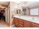 Well-lit bathroom with double vanity, large mirror, and ample storage in wood cabinets at 9352 W Pioneer St, Tolleson, AZ 85353