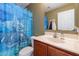 Cozy bathroom featuring a dolphin shower curtain, functional sink, and well-maintained toilet at 9352 W Pioneer St, Tolleson, AZ 85353