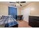 Comfortable bedroom with ceiling fan, desk, closet, and modern dresser for storage at 9352 W Pioneer St, Tolleson, AZ 85353