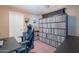 This bedroom is furnished with a black gaming chair and has floor to ceiling shelving that is used for record storage at 9352 W Pioneer St, Tolleson, AZ 85353