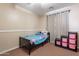 Bright bedroom with carpet, neutral walls, and convenient toy storage at 9352 W Pioneer St, Tolleson, AZ 85353