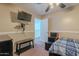 Bright bedroom featuring a TV, neutral walls, and convenient access to the hallway at 9352 W Pioneer St, Tolleson, AZ 85353