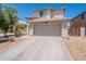 View of a two-story home with desert landscaping, a two-car garage, and a driveway at 9352 W Pioneer St, Tolleson, AZ 85353