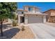 Tan two-story house with a two-car garage, desert landscaping, and tiled roofing at 9352 W Pioneer St, Tolleson, AZ 85353