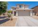 Two-story home featuring a neutral color scheme, two-car garage, desert landscaping, and tile roof at 9352 W Pioneer St, Tolleson, AZ 85353