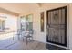 Covered front porch with two chairs and a decorative security door at 9352 W Pioneer St, Tolleson, AZ 85353